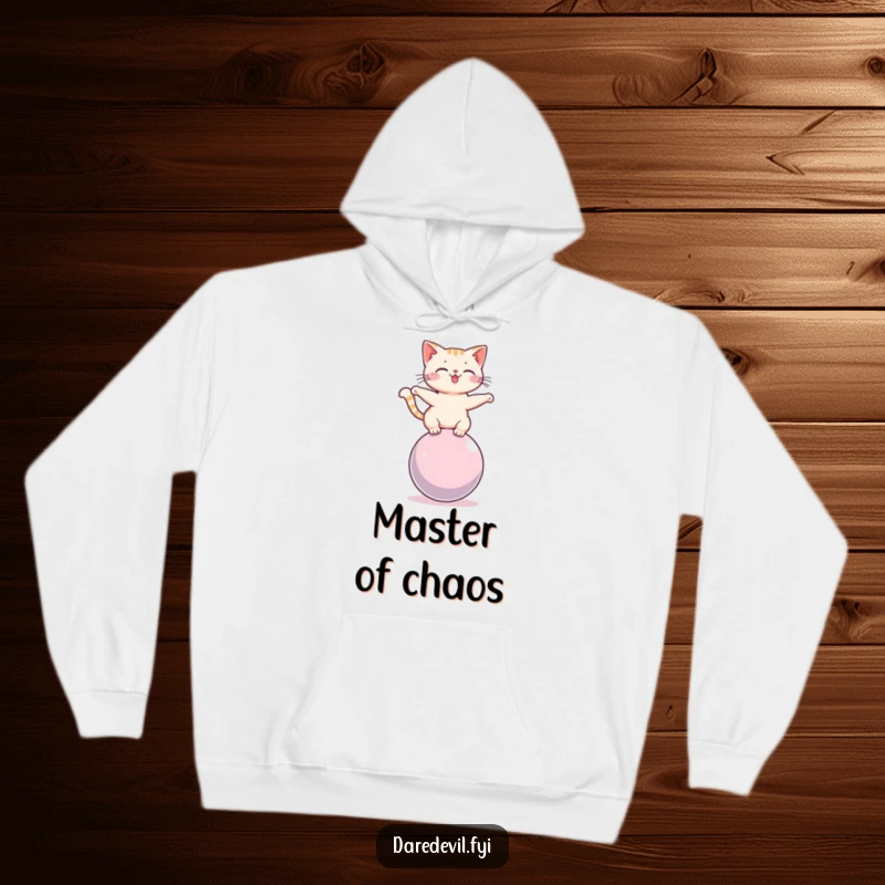 Funny cat balancing on a rolling sphere, depicted on a soft, warm hoodie, ideal for cozy, humorous lounging.