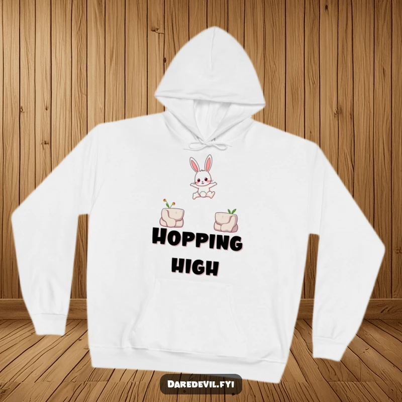 Funny hoodie depicting a brave rabbit character leaping across a small gap between two tiny platforms, conveying courage humorously.