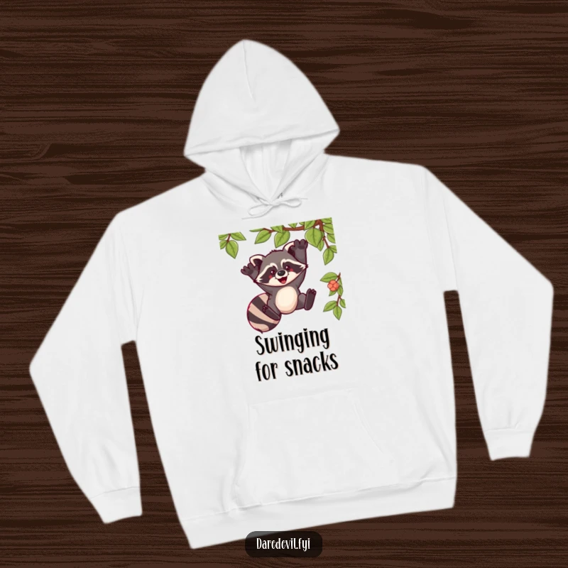 Funny hoodie depicting a raccoon swinging exuberantly from a vine, offering warmth and a humorous, adventurous vibe.